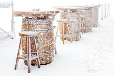Winter outdoor barrels covered in snow.