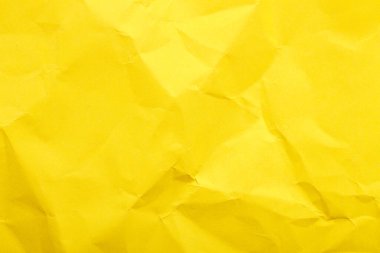 Parlak buruşuk yüzeyi olan buruşuk sarı kağıt dokusu.