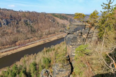 Sakin nehir manzarası üzerindeki kayalık uçurumların panoramik görüntüsü.