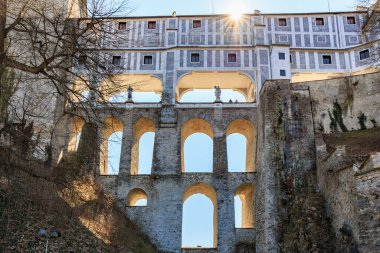 Parlak güneş ışığında kemerli köprüsü olan tarihi şato.