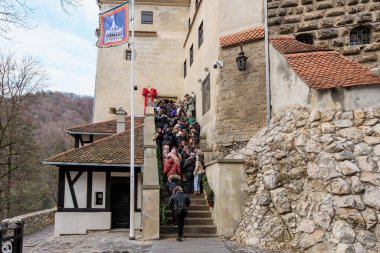 Bir grup insan taş bir merdivenden yukarı çıkıyorlar. 16 Aralık 2024 Bran Romanya.