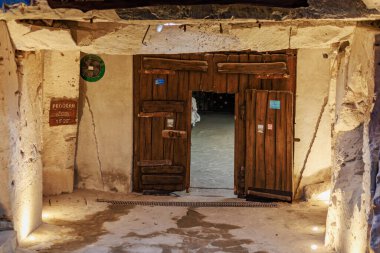 Tarihi ahşap kapı, sıcak ışıklandırmalı antik taş bina. 6 Nisan 2025 Branesti, Moldova.