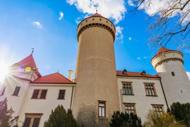 Muhteşem ortaçağ taş kalesine karşı parlak mavi gökyüzü ve güneş ışığı. 17 Mart 2025, Konopiste Şatosu, Çek Cumhuriyeti.