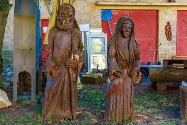 Bahçedeki erkek ve kadın figürlerinin kırsal ahşap heykelleri. 16 Mart 2025, Hruba Skala Şatosu, Çek Cumhuriyeti.