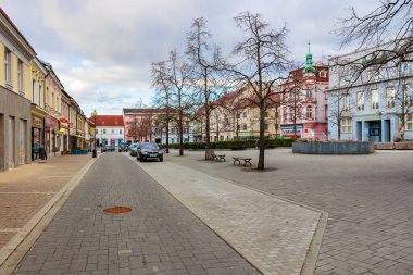 Çıplak ağaçlar ve tarihi mimarisi olan sakin bir Avrupa şehir meydanı. 17 Mart 2025, Benesov, Çek Cumhuriyeti.