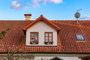 Huzur içinde yatağı ve çanağı olan kırmızı kiremitli bir çatı evi. 17 Mart 2025, Benesov, Çek Cumhuriyeti.