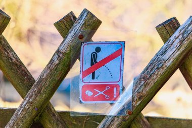 Kırsal çitlerde yasak tabelası ve açık havada sembolik grafikler. 18 Mart 2025, Madalyon, Çek Cumhuriyeti.