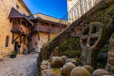 Tarihi şato avlusunda tarihi mimariyle birlikte ortaçağ taş haçı. 18 Mart 2025, Madalyon, Çek Cumhuriyeti.