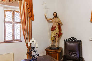 Antik oda ortamında haç tutan İsa 'nın dini heykeli. 18 Mart 2025, Madalyon, Çek Cumhuriyeti.