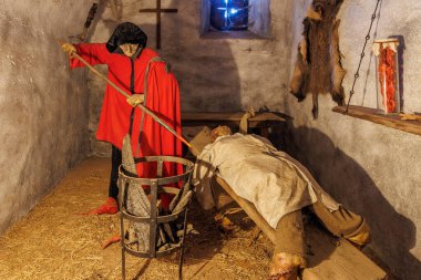 Ortaçağ işkence sahnesinde cellat ve kurban zindan düzeninde. 18 Mart 2025, Madalyon, Çek Cumhuriyeti.
