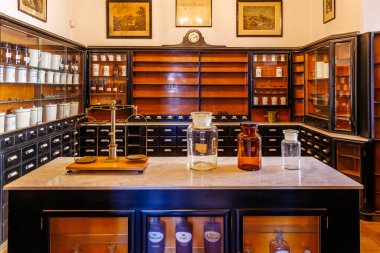 Ahşap rafları ve cam kavanozları olan antika bir eczane. 18 Mart 2025, Madalyon, Çek Cumhuriyeti.