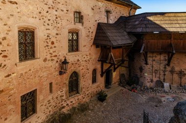 Taştan duvarları ve tahta kirişleri olan bir ortaçağ kalesi avlusu. 18 Mart 2025, Madalyon, Çek Cumhuriyeti.