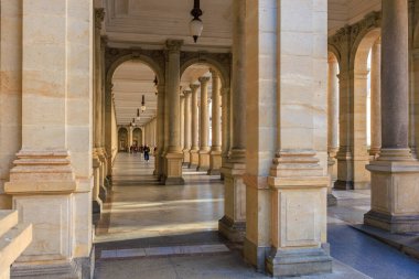 Taştan kemerler ve günışığında sütunları olan tarihi sütunlar. 18 Mart 2025, Karlovy Vary, Çek Cumhuriyeti.