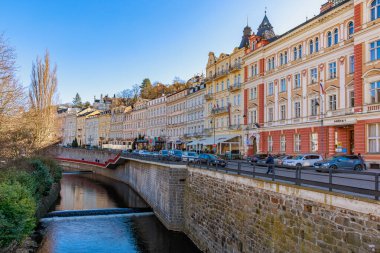 Karlovy 'nin tarihi mimarisi ve manzaralı kanal manzarası çeşitlilik gösterir. 18 Mart 2025, Karlovy Vary, Çek Cumhuriyeti.