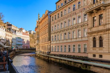 Çekici şehir ortamındaki tarihi Avrupa mimarisi manzaralı nehir boyunca. 18 Mart 2025, Karlovy Vary, Çek Cumhuriyeti.