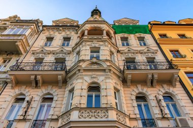 Süslü balkonları ve karmaşık detayları olan tarihi Avrupa mimari cephesi. 18 Mart 2025, Karlovy Vary, Çek Cumhuriyeti.