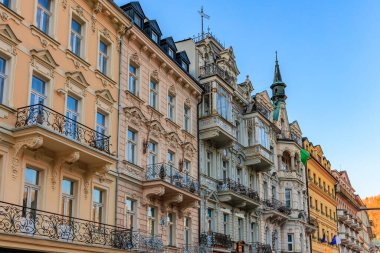 Gün batımında Avrupa şehir manzarasında süslü cepheli renkli tarihi binalar. 18 Mart 2025, Karlovy Vary, Çek Cumhuriyeti.