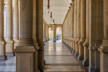 Mermer sütunlu ve zarif ışıklandırmalı büyük mimari koridorlar. 19 Mart 2025, Karlovy Vary, Çek Cumhuriyeti.