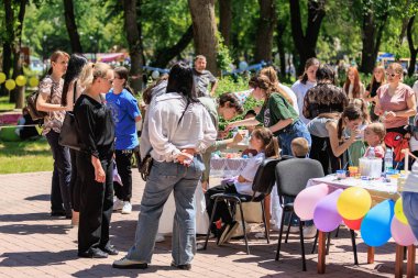 Açık hava toplumu çeşitli aileler ve etkinliklerle meşgul çocuklarla bir araya geliyor. 22 Mayıs 2025 Balti Moldova.