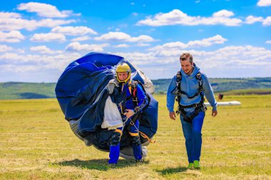 Güneşli bir günde paraşüt taşıyan iki beyaz erkek. 31 Mayıs 2025 Vadul lui Voda Moldova.