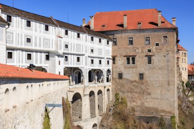 Güneşli bir günde tarihi Cesky Krumlov şatosu, kemerli köprüsü ve yüksek duvarları var. 20 Mart 2025, Cesky Krumlov, Çek.