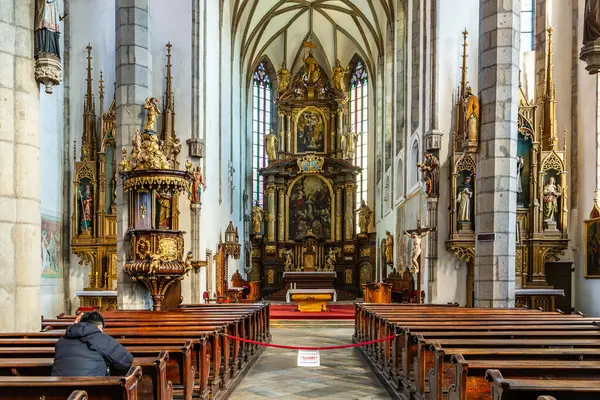 Avrupa 'daki tarihi Katolik kilisesinin ahşap sıraları ve sunaklarıyla süslenmiş. 20 Mart 2025, Cesky Krumlov, Çek.