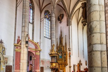 Süslü sunakları ve vitray pencereleri olan tarihi gotik kilise iç mimarisi. 20 Mart 2025, Cesky Krumlov, Çek.