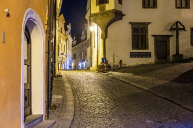 Tarihi binaları ve yumuşak ışıklandırması olan gece vakti kaldırım taşı caddesi. 20 Mart 2025, Cesky Krumlov, Çek.