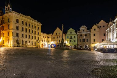 Yanan binalarla dolu tarihi kasaba meydanının gece manzarası. 20 Mart 2025, Cesky Krumlov, Çek.