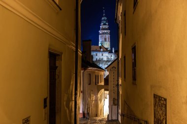 Geceleyin aydınlık kule manzaralı tarihi bir Czech kasabası. 20 Mart 2025, Cesky Krumlov, Çek.