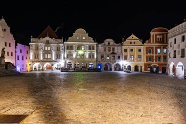 Geceleyin, renkli binalarla aydınlatılmış tarihi Czech şehir meydanı. 20 Mart 2025, Cesky Krumlov, Çek.