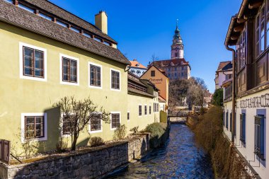 Nehir akan küçük bir kasaba. Binalar eski ve yeşil renkli. 21 Mart 2025, Cesky Krumlov, Çek.