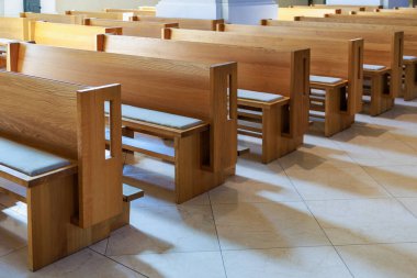 Boş ahşap kilise sıraları güneşli iç kısımda fayanslı döşemeler ve yumuşak yastıklar..