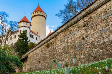 Parlak bir günde taş duvarları ve kırmızı kuleleri olan tarihi ortaçağ kalesi.