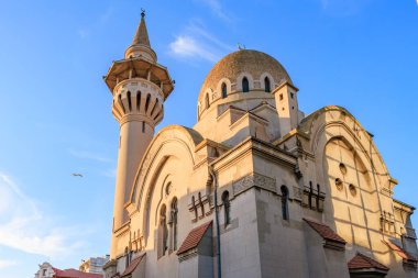 Mavi gökyüzünün altında minaresi ve kubbesi olan tarihi bir cami..