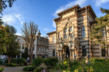 Açık bir günde tarihi Romen mimarisi binalar ve yemyeşil bahçeler süslüyor. 3 Mayıs 2025 Romanya.