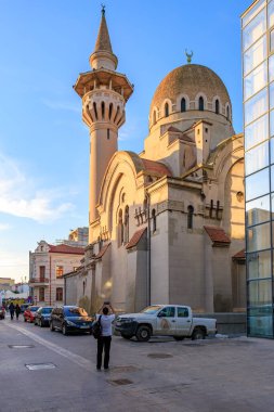 Gün batımında şehir sokağında kulesi olan görkemli bir cami. 3 Mayıs 2025 Romanya.