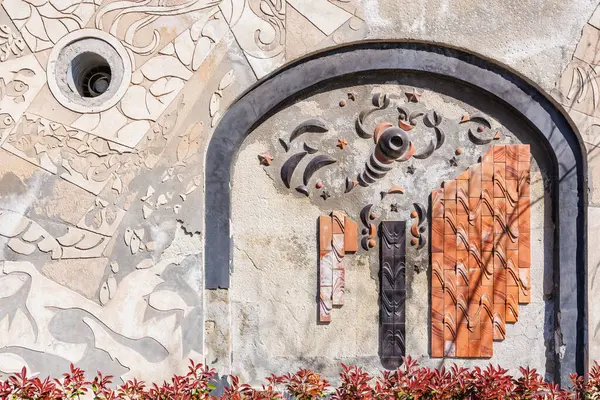 Karmaşık desenleri ve kırmızı yaprakları olan soyut geometrik duvar sanatı. 3 Mayıs 2025 Romanya.