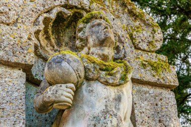 Açık havada yosun bulunan eskimiş taş heykel. 17 Mart 2025, Konopiste Şatosu, Çek Cumhuriyeti.