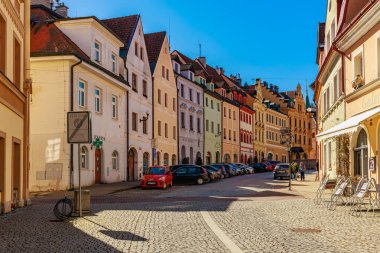 Tarihi binaları ve kaldırım taşları yolu olan renkli Avrupa caddesi. 18 Mart 2025, Madalyon, Çek Cumhuriyeti.