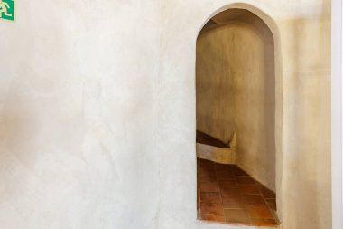 Tarihi binada eğri tuğlalı basamaklar olan dar kemerli bir geçit. 18 Mart 2025, Madalyon, Çek Cumhuriyeti.