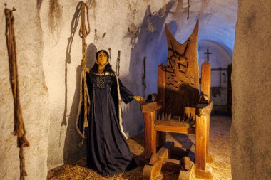 Ortaçağ işkence müzesi sahnesinde kadın manken ve çivili sandalye. 18 Mart 2025, Madalyon, Çek Cumhuriyeti.