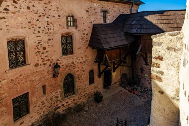 Taş duvarları ve ahşap çatıları olan tarihi ortaçağ kalesi avlusu. 18 Mart 2025, Madalyon, Çek Cumhuriyeti.