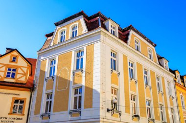 Sarı cepheli ve mavi gökyüzlü tarihi Avrupa mimarisi. 18 Mart 2025, Madalyon, Çek Cumhuriyeti.