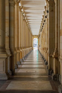 Güneşli koridorda taş sütunları olan zarif bir sütun..