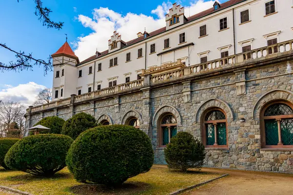 Taştan duvarları ve mavi gökyüzünün altında manikürlü bahçeleri olan tarihi Avrupa kalesi.
