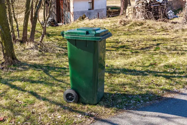 Güneşli bir günde kırsal alanda yeşil atık kutusu.