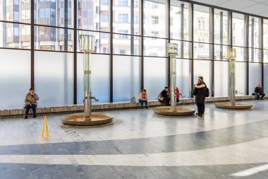 İnsanların oturduğu ve eşsiz su çeşmelerinin yanında durduğu kapalı bir alan. 18 Mart 2025, Karlovy Vary, Çek Cumhuriyeti.