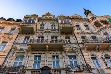 Dekoratif unsurlar ve balkonlarla tarihi bina cephesini süsleyin. 18 Mart 2025, Karlovy Vary, Çek Cumhuriyeti.
