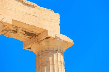 Arka planda mavi gökyüzü olan bir sütun. Sütun taştan yapılmıştır ve yıpranmış bir görünüşü vardır.